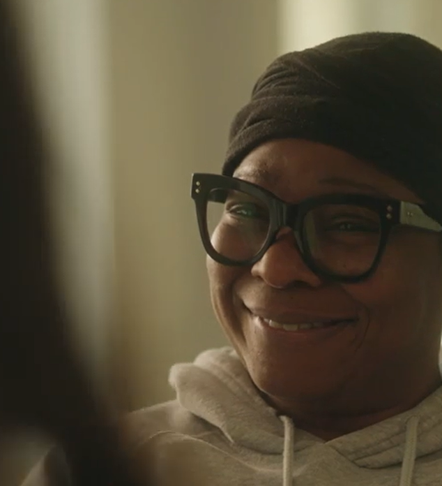 black woman with glasses smiling